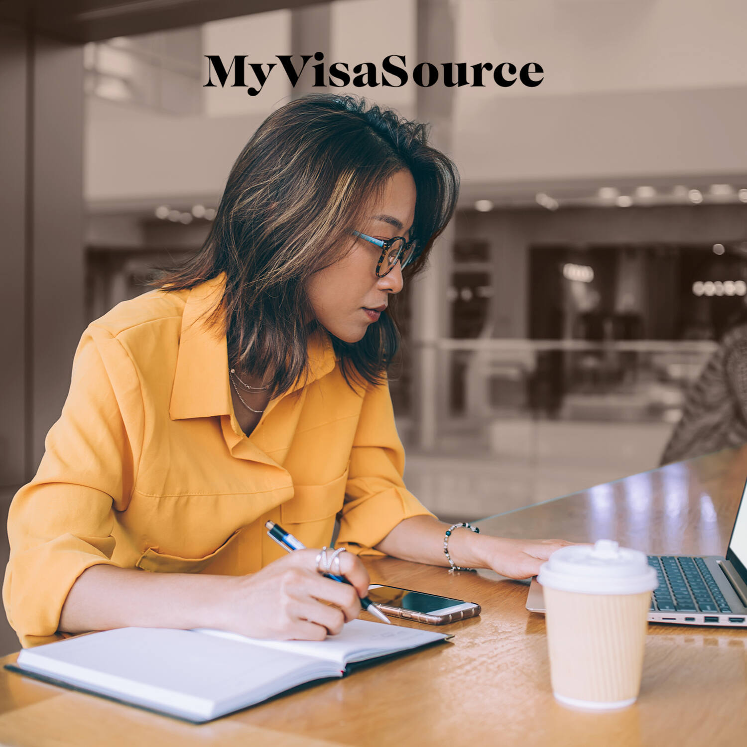 woman studying hard at coffeeshop my visa source